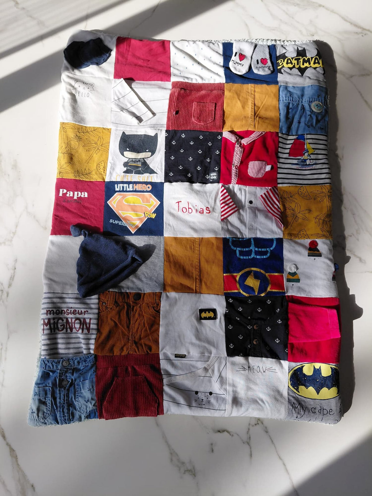 Patchwork de vêtements bébé ou enfant ou être cher disparu. Prénom brodé à la main. Accessoires bébé incrustés. Couverture souvenir épaisse 75x90cm. Parfaite pour un enfant.
